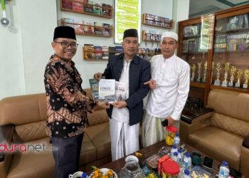Pengasuh IBS PKMKK Pamekasa, Achmad Muhlis dan Muhammad Holis menyerahkan kenang-kenagan buku tentang pondok pesantren setempat, Sabtu (4/4/2026).